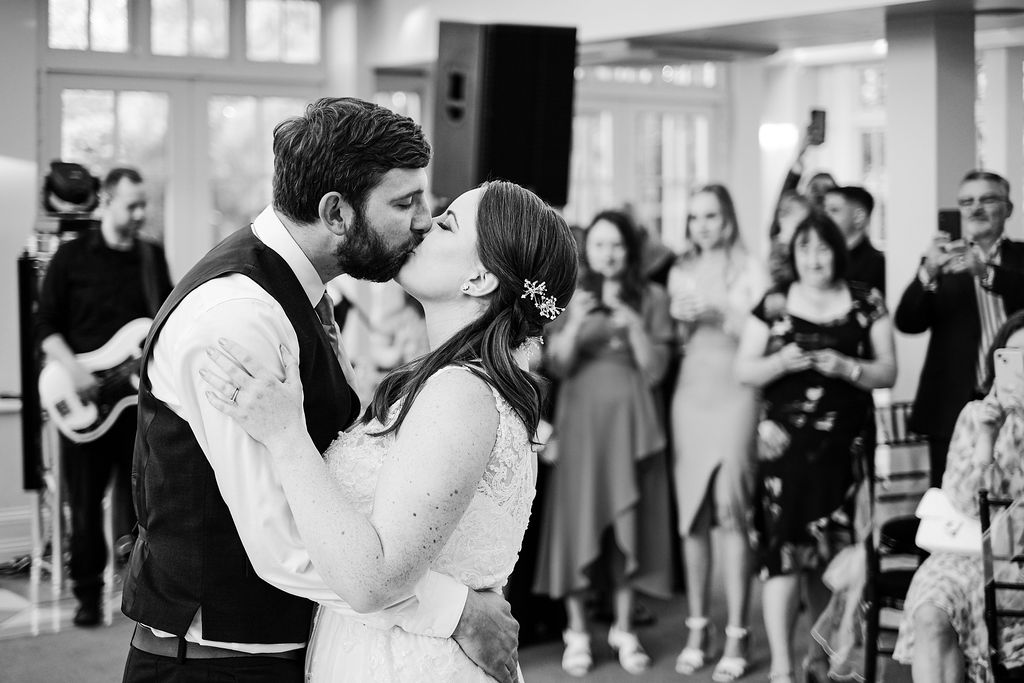 Bride and groom kiss on dance-floor, Swynford Manor