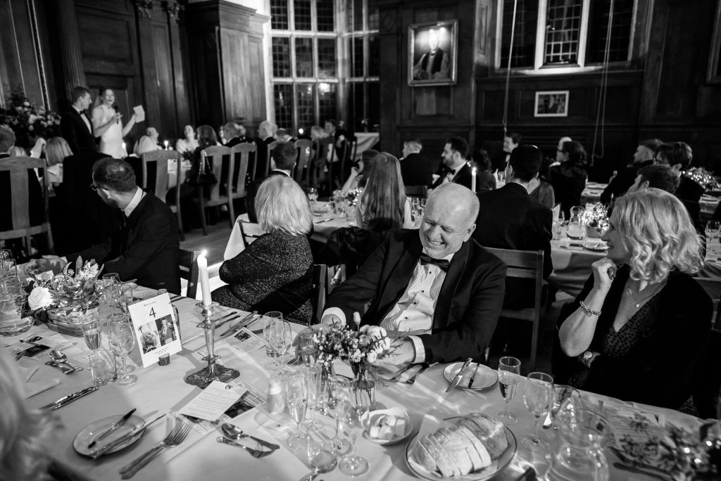 Laughing at dinner, Selwyn College, Cambridge wedding photography